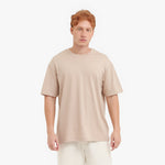Man wearing a beige t-shirt on a white background