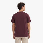 Back view of a man wearing a maroon t-shirt on a white background