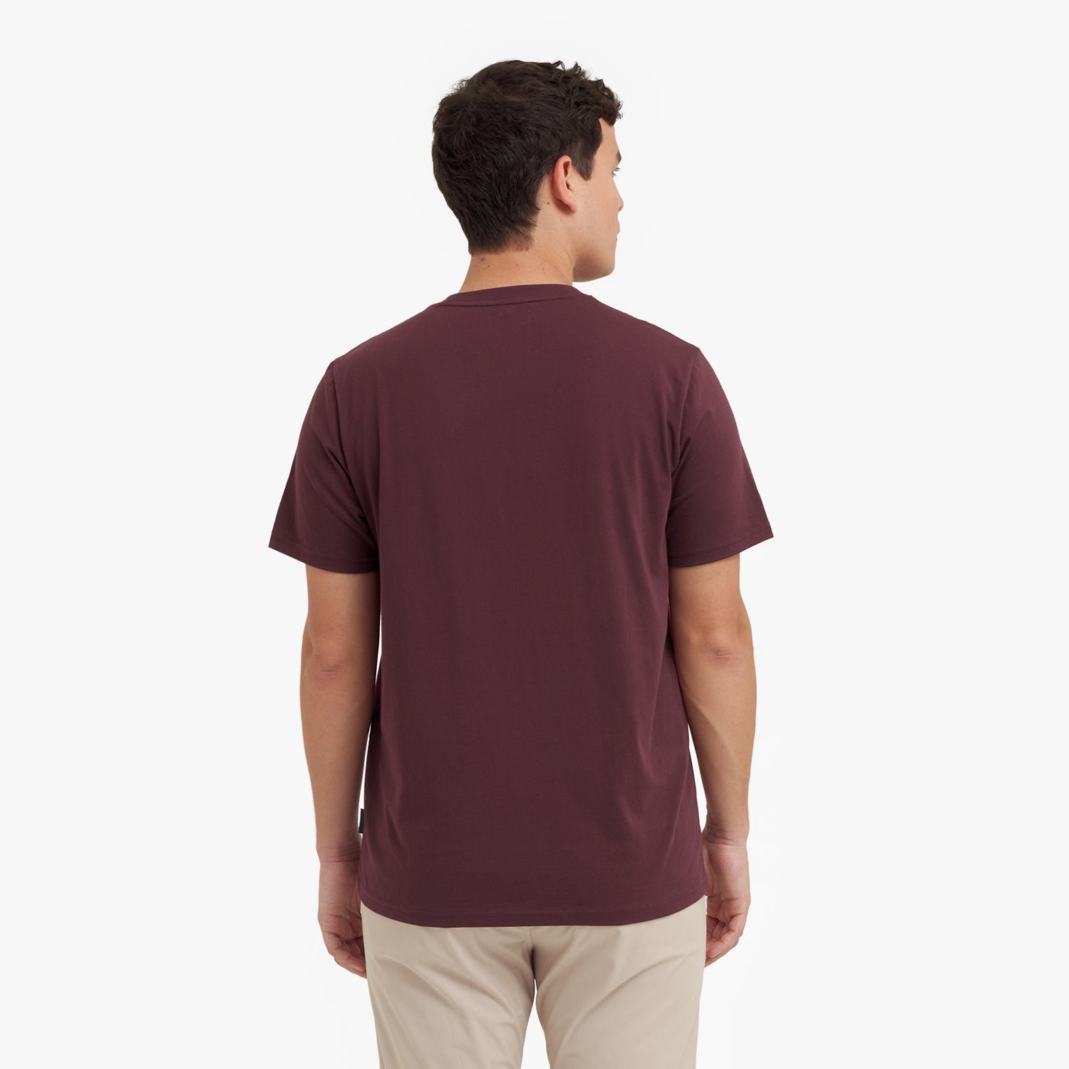 Back view of a man wearing a maroon t-shirt on a white background