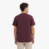 Back view of a man wearing a maroon t-shirt on a white background