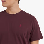 Close-up of a maroon t-shirt with a small red logo on a white background
