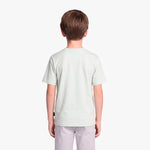 A child viewed from the back wearing a light green T-shirt and light gray pants