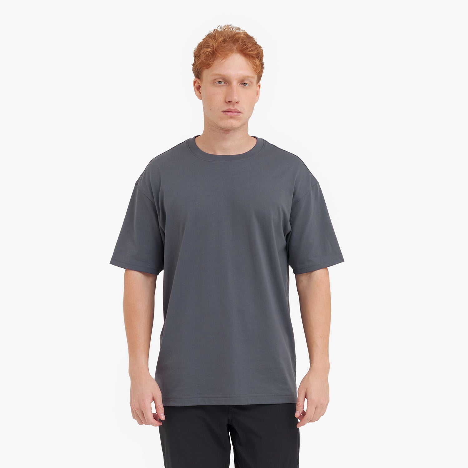 Man wearing a plain gray t-shirt on a white background