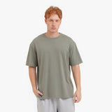 Man wearing a plain green t-shirt on a white background