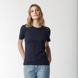 Front view of a woman wearing a navy blue t-shirt and blue jeans.